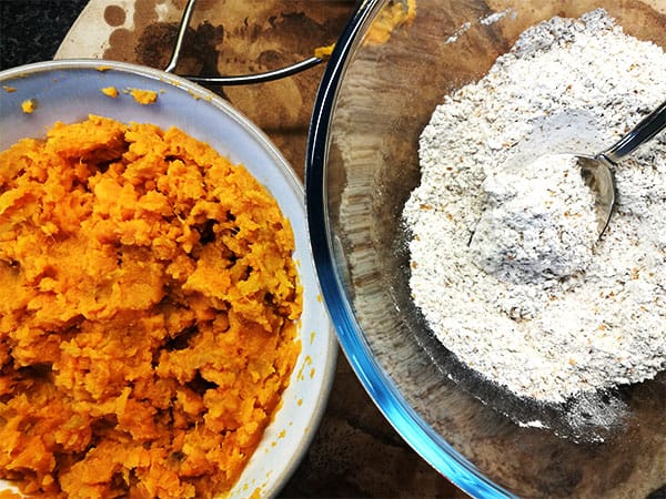 mashed sweet potatoes in bowl and flour in another bowl used for sweet potato flatbread.