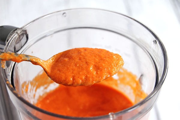 Spoonful of finished red pepper Romesco sauce in blender