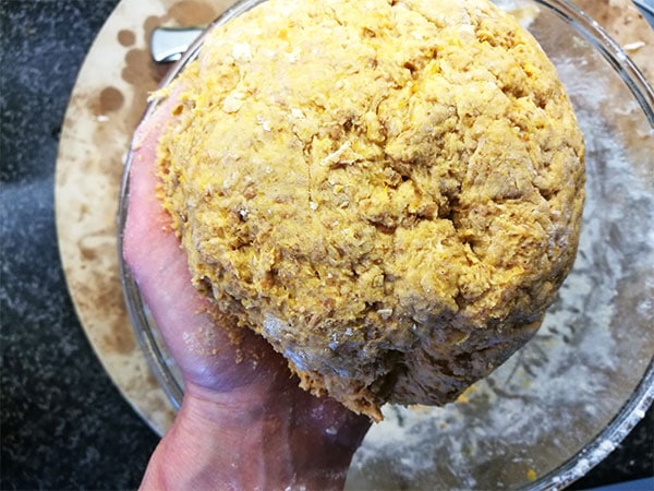 Dough made with sweet potatoes and flour is being held in hand.