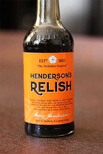 Bottle of Henderson's relish on brown metal table