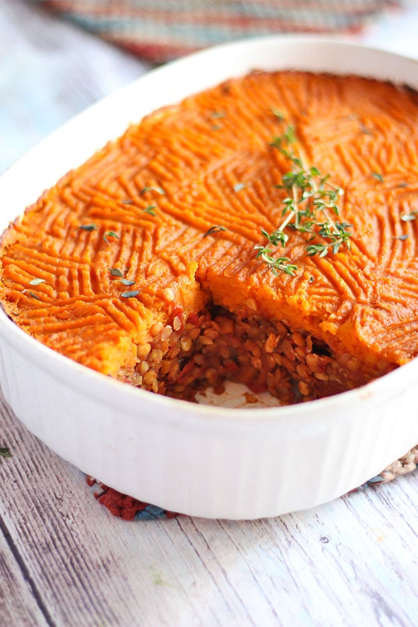 sweet potato crust over lentil and vegetable filling in white casserole dish