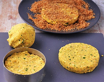 Chickpea burger patties being made and rolled into breadcrumbs.