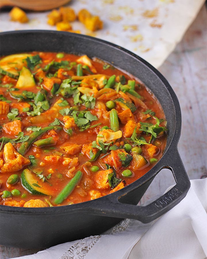 Tomato vegetable curry with crispy tofu in black pan