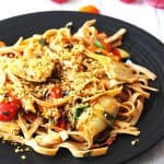 pasta with cherry tomatoes, artichoke hearts, fresh basil and hemp seed Parmesan on black plate