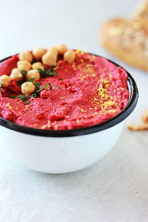 red spicy beetroot hummus (oil free) with chickpeas, chopped mint and lemon zest on top.