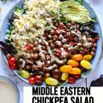 Middle Eastern chickpea salad with lettuce greens, chickpeas, bulgur, cherry tomatoes, dressing and sliced avocado with text overlay of recipe title.