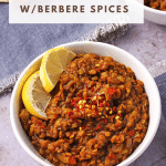 Ethiopian lentils with Berbere spice blend in white bowls garnished with lemon wedges and red chili flakes.