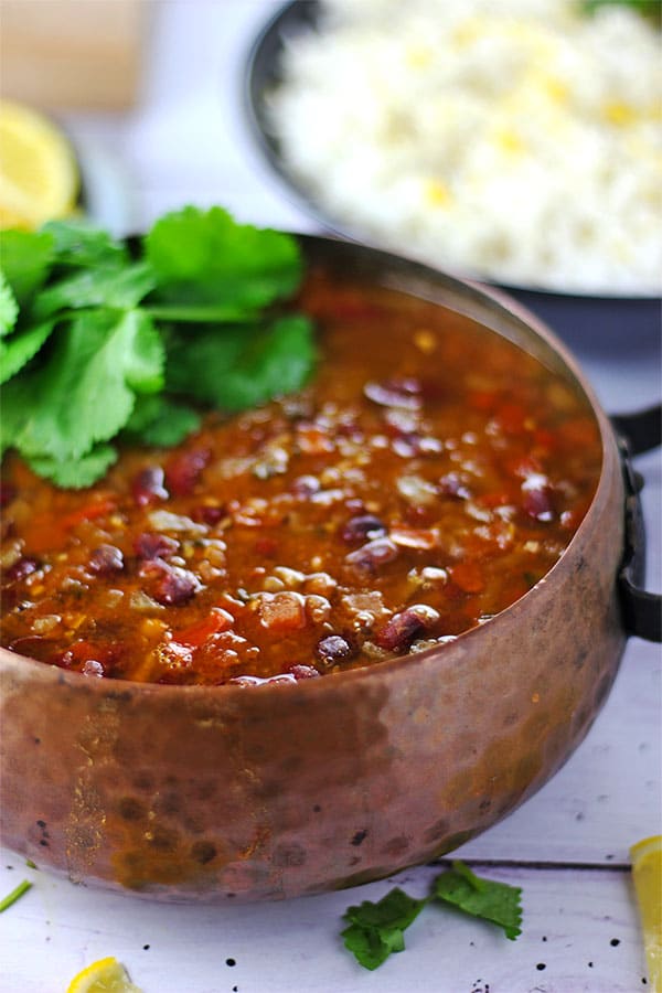 kidney bean curry with cilantro in brown metal pot.