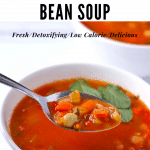 Fava bean soup (broad bean soup or Ful Nabed) with vegetables and tomatoes in white bowl with spoon and text overlay with recipe title.