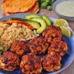 Roasted BBQ cauliflower with pepita dressing and cilantro-lime quinoa on blue plate.
