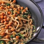 Chickpea pasta sauce with rosemary and spinach with tagliatelle in black skillet with chickpeas in background and text overlay with recipe title.