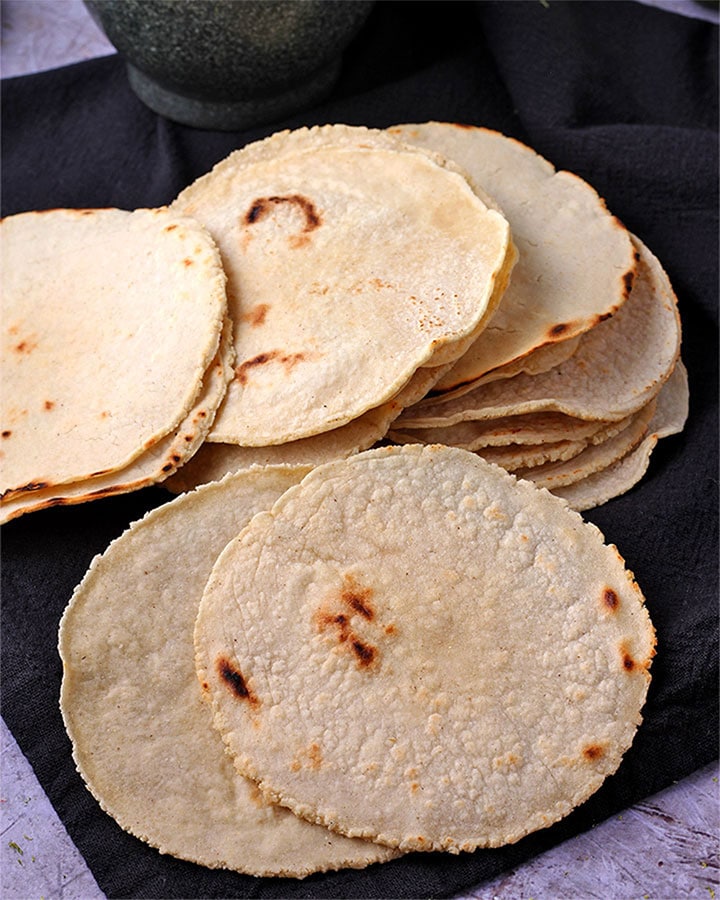 toasted corn tortillas are laid on black cloth