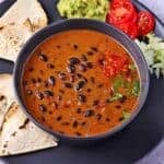 Saucy chipotle black beans in black bowl overhead