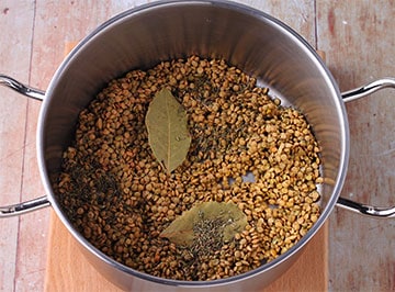 Lentils are rinsed and placed in pot with dried thyme and bay leaves