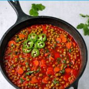 Pea stew with sliced carrots, tomato sauce and cilantro garnished with sliced fresh jalapeno and chopped cilantro.