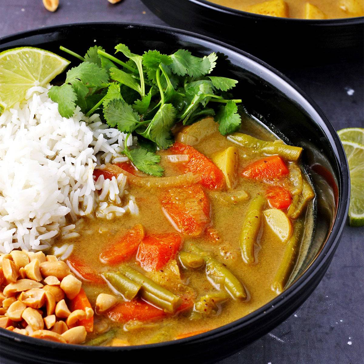 Veggie massaman curry with potaotes, green beans, carrots, onions and massaman curry paste with rice, chopped peanuts and cilantro