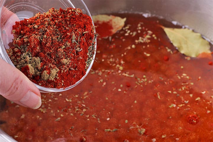 smoked paprika, cumin, thyme and oregano is added to cooking pot with bay leaves and chickpeas