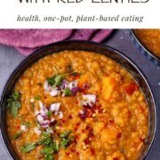 sweet potato dahl with red lentils in black bowl overhead with coriander, diced red onions and red chili on top and text overlay with recipe title.