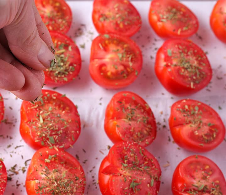 herbs de province are added to halved tomatoes