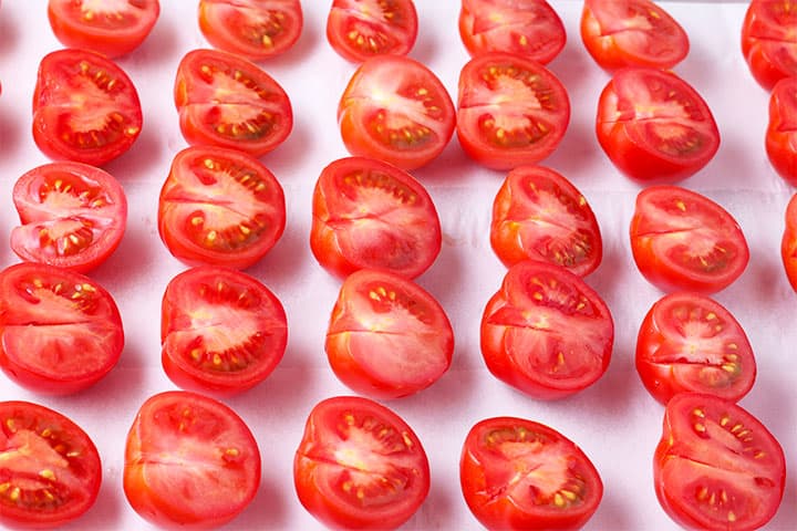 fresh tomatoes are sliced in half