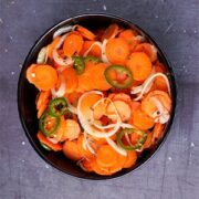 spicy Escabeche, Mexican pickled carrots, onions and jalapenos in black bowl