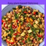 Blue bowl with chickpeas, diced zucchini, yellow and red bell peppers, red onions and chopped parsley.