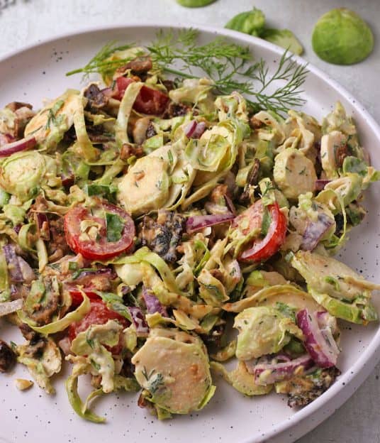 Shaved Brussels sprouts salad with bacon, red onion, tomatoes, and ranch dressing