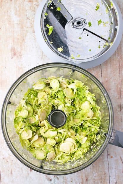 Brussels sprouts are sliced in a food processor