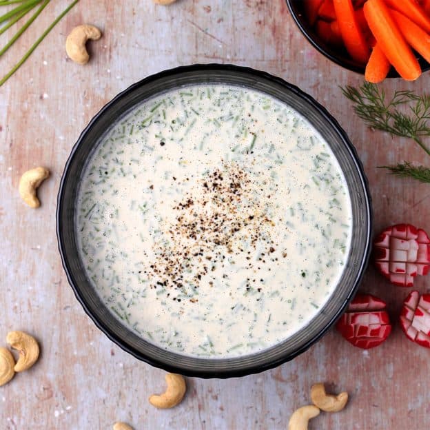 plant-based cashew ranch dressing in a black bowl with ground pepper