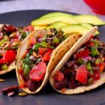 kidney bean tacos with grapefruit salsa on black plate