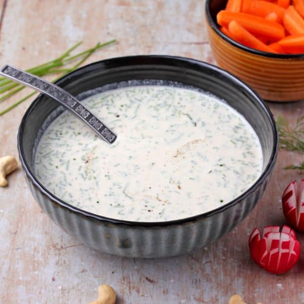plant-based cashew ranch dressing in a black bowl with a spoon