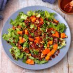 roasted sweet potatoes with wheat berries, endive, scallions, carrots, cranberries, walnuts, and soy ginger dressing on blue plate