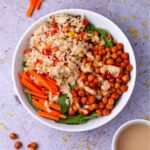 spicy buffalo chickpea and rice bowls with bowl of ginger tahini dressing in white bowl