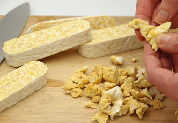 Tempeh is sliced and then crumbled by hand into pieces