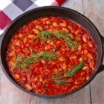 Gigantes Plaki, Greek Baked beans with tomato sauce and stems of dill on top.