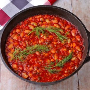 Gigantes Plaki, Greek Baked beans with tomato sauce and stems of dill on top.