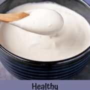 Plant-based sour cream in a blue bowl with a small wooden spoon.