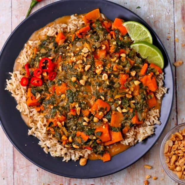 Satay sweet potato curry is served over black rice with chopped peanuts.