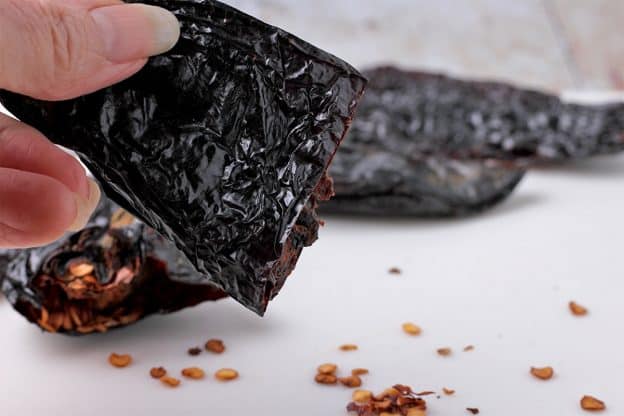 The seeds are removed from a dried ancho chili pepper.