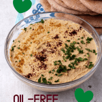 Oil-free hummus in a glass bowl with a text overlay with recipe title.