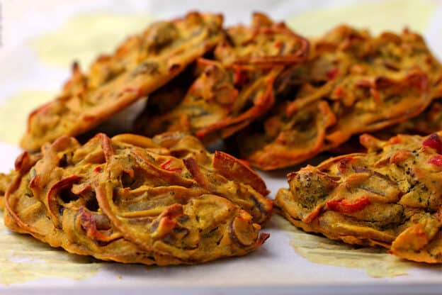Pakoras are baked on a tray with parchment paper.