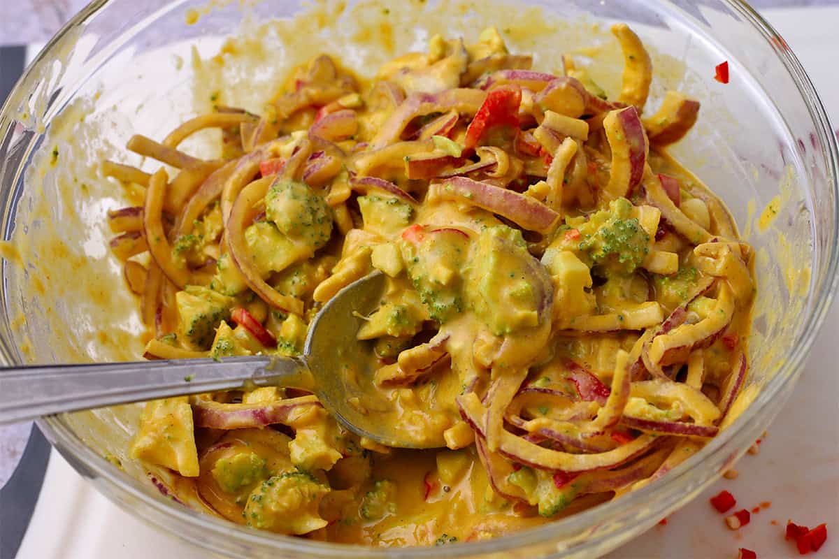 Broccoli, red onion slices, and red chili is mixed in a chickpea flour batter.