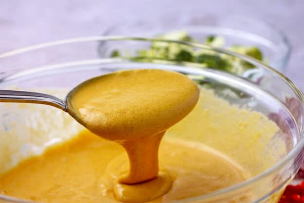 A batter is made with chickpea flour, turmeric, cumin, and salt.