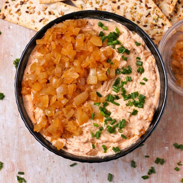 Vegan French Onion dip in a bowl with chopped chives and caramelized onions.