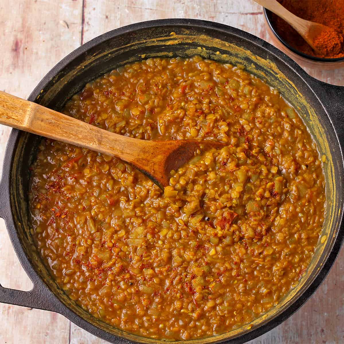 Misir Wot (Ethiopian Lentil stew) in a black pot with a wooden spoon