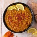 Red lentils in a bowl with Berbere spices and lemon slices.