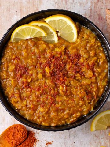 Red lentils in a bowl with Berbere spices and lemon slices.
