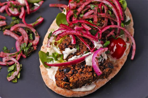 Black bean vegan koftas with red onions, lettuce, tomatoes, and aioli.