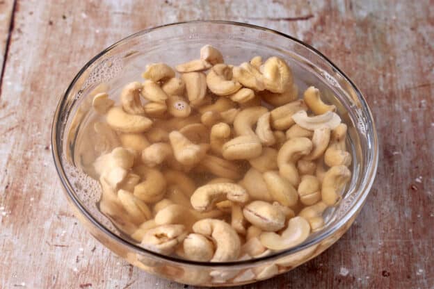 Cashews are soaked in a bowl of water.