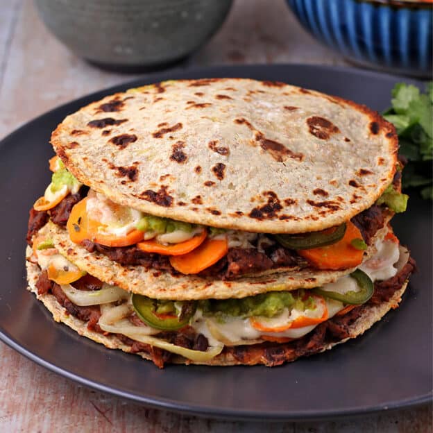 A stacked quesadilla is made with whole wheat potato tortillas and stuffed with vegan Mexican favorites.